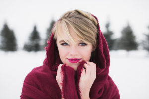 senior girl with blonde hair wearing a maroon scarf draped on her head and shoulders