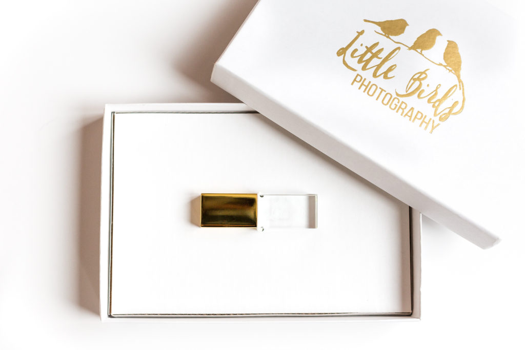glass usb drive with gold cap in white box with Little Birds Photography logo