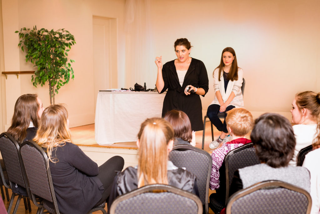 Mary Kay Consultant leading a makeup tutorial for high school girls at Little Birds Photography's Glitter & Glam Night 