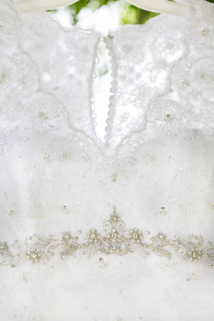 closeup of the intricate beaded and lace neckline of the wedding dress