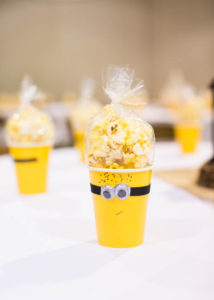 cups that look like yellow minions filled with bags of popcorn