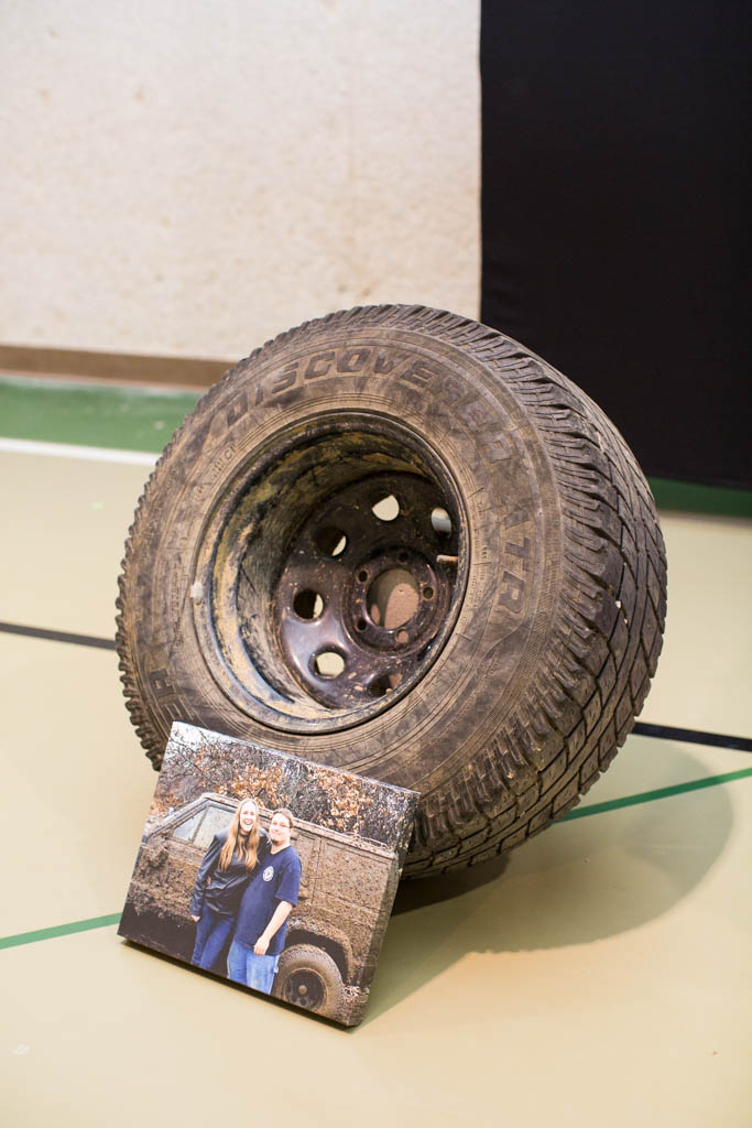 muddy tire with a canvas of the bride and groom resting on it