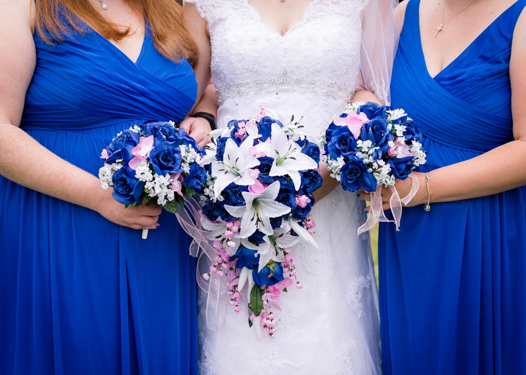 close up of the bride and bridesmaids holding their blue, pink and white bouquets