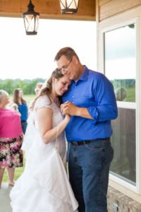 dad holds his daughter close during the father daughter dance