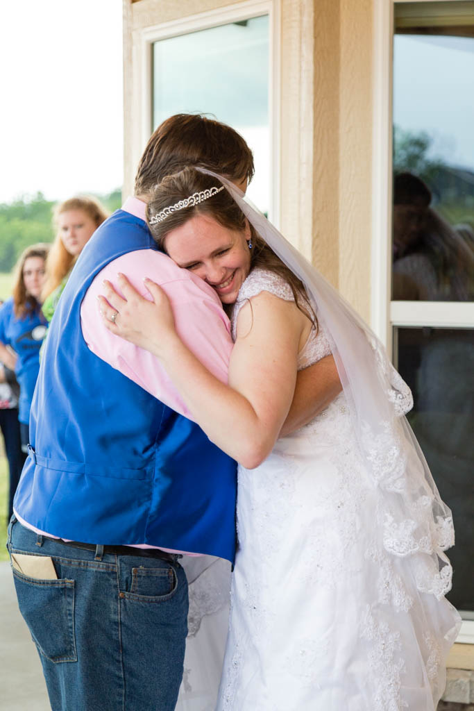 bride rests her head on the groom's shoulder and smiles during their first dance
