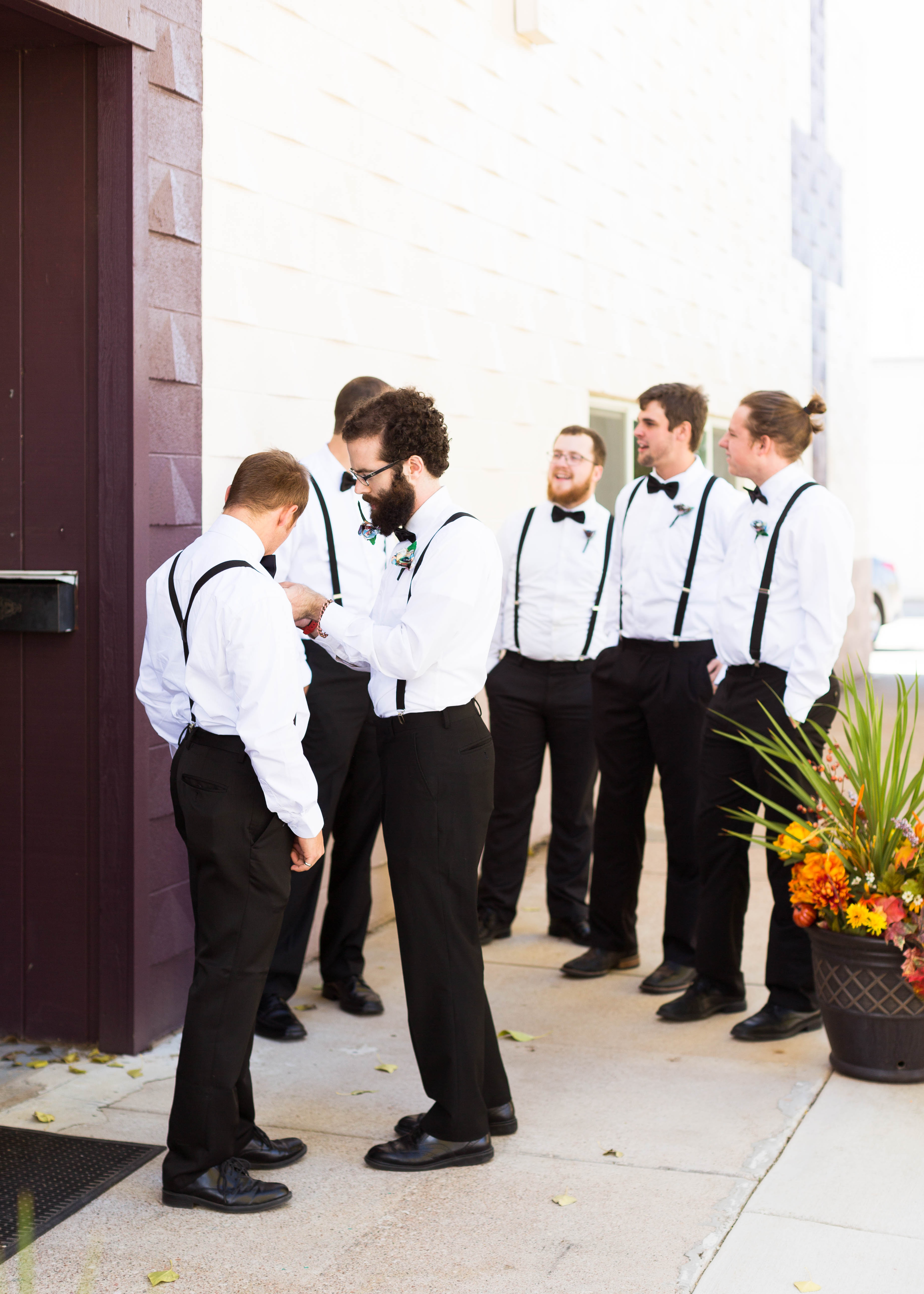 groomsmen chat as they put on boutonierres