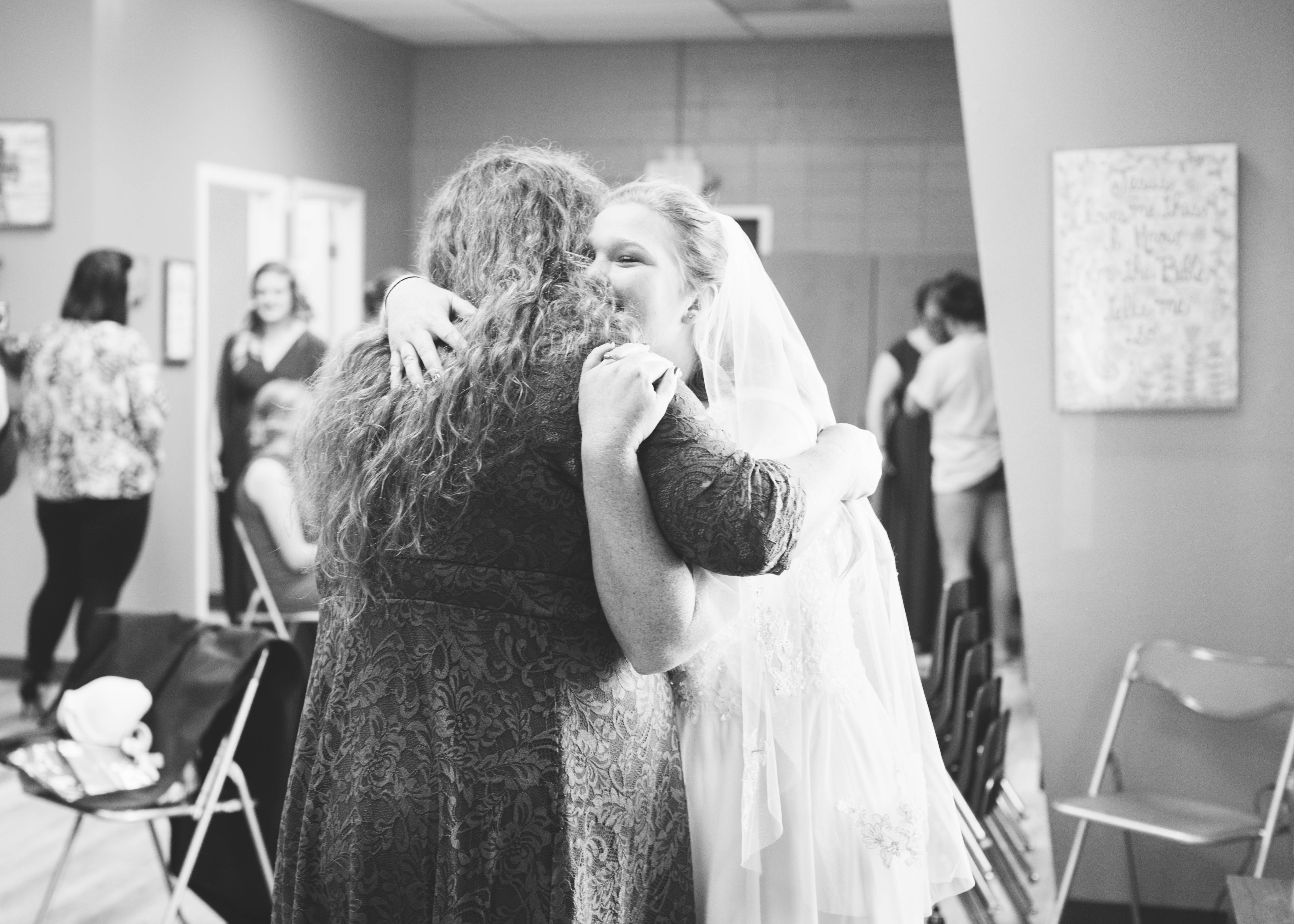 bride embraces her mom as she is getting ready