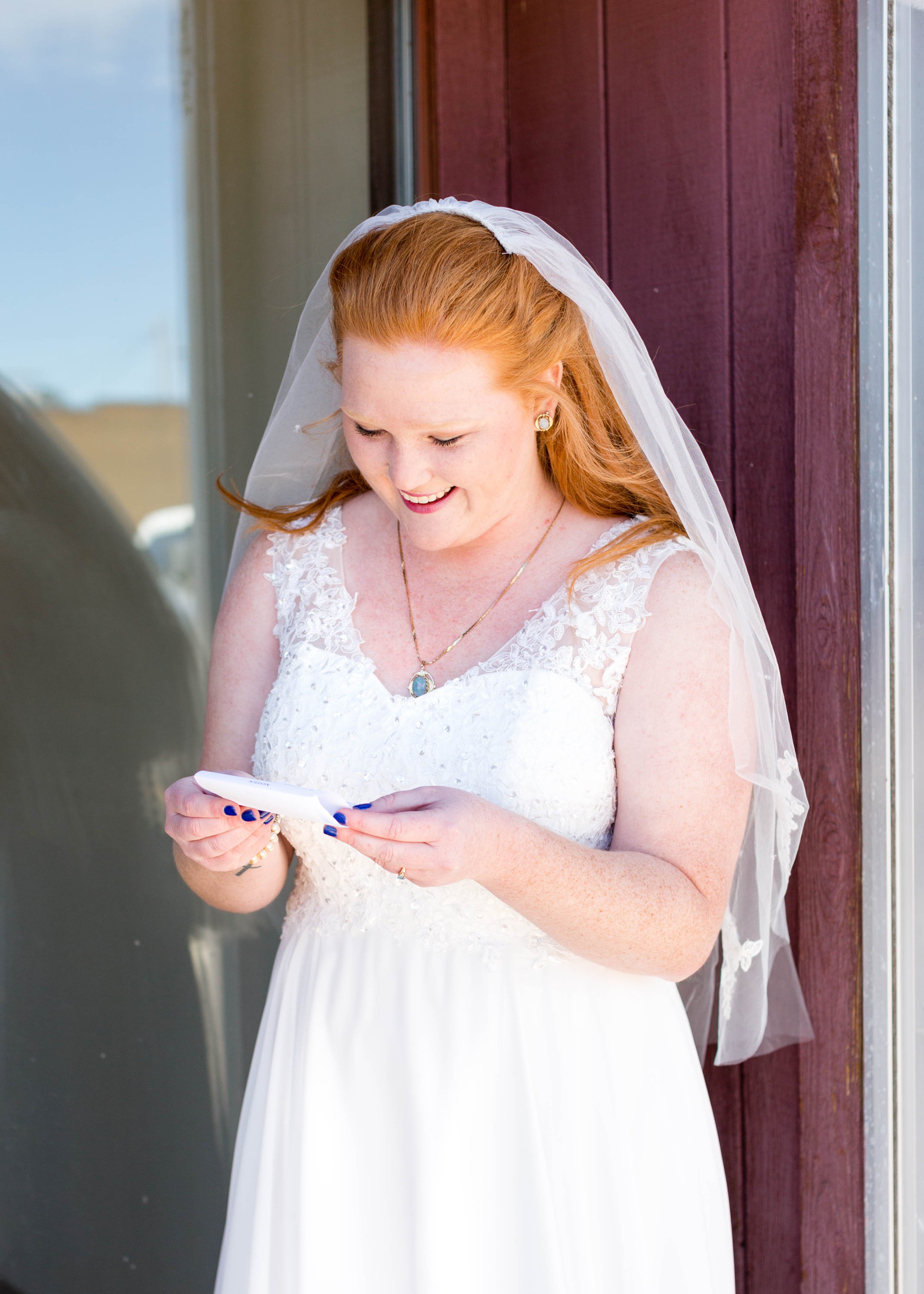 bride laughs as she reads note from her groom