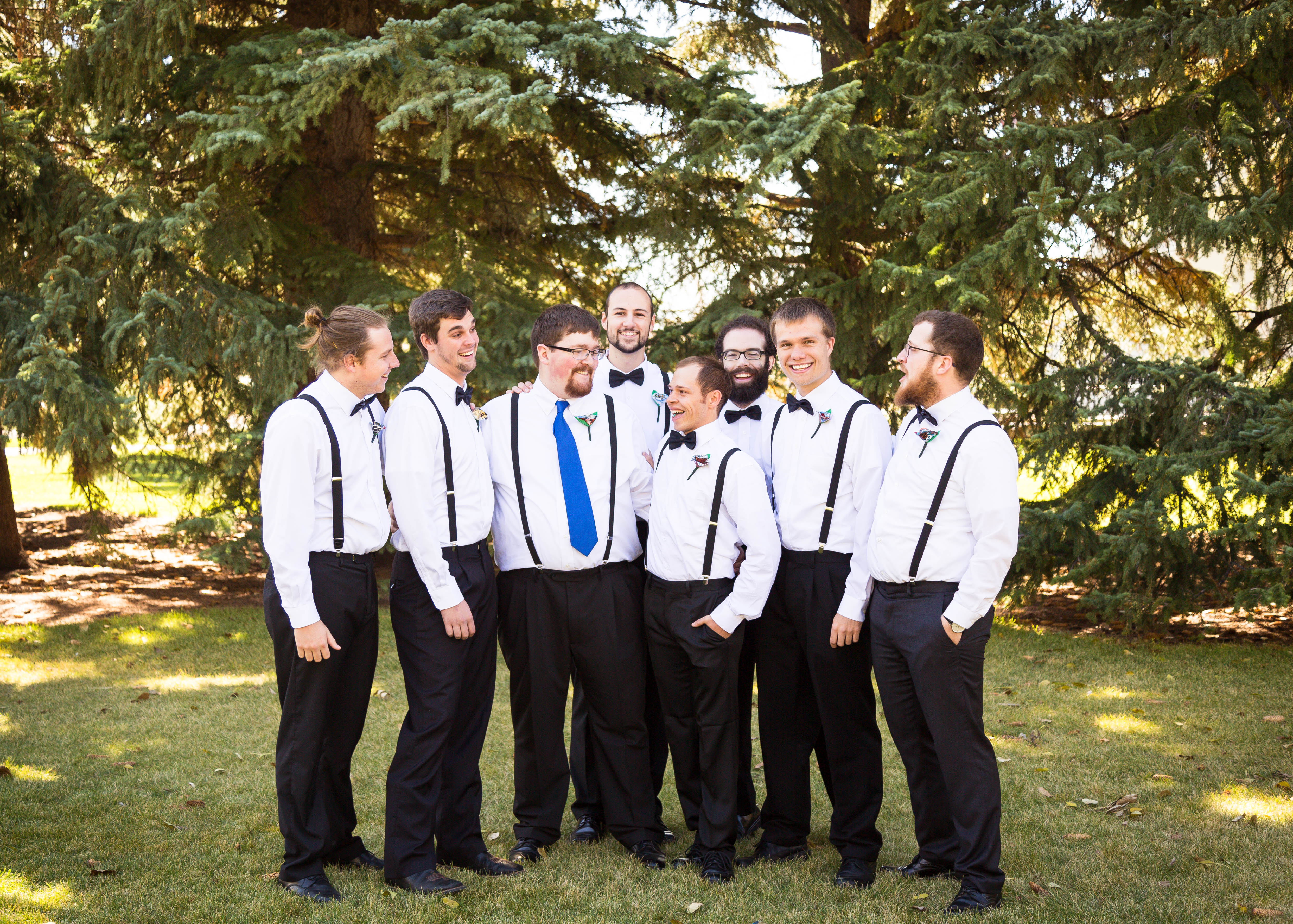 groomsmen surround groom and laugh