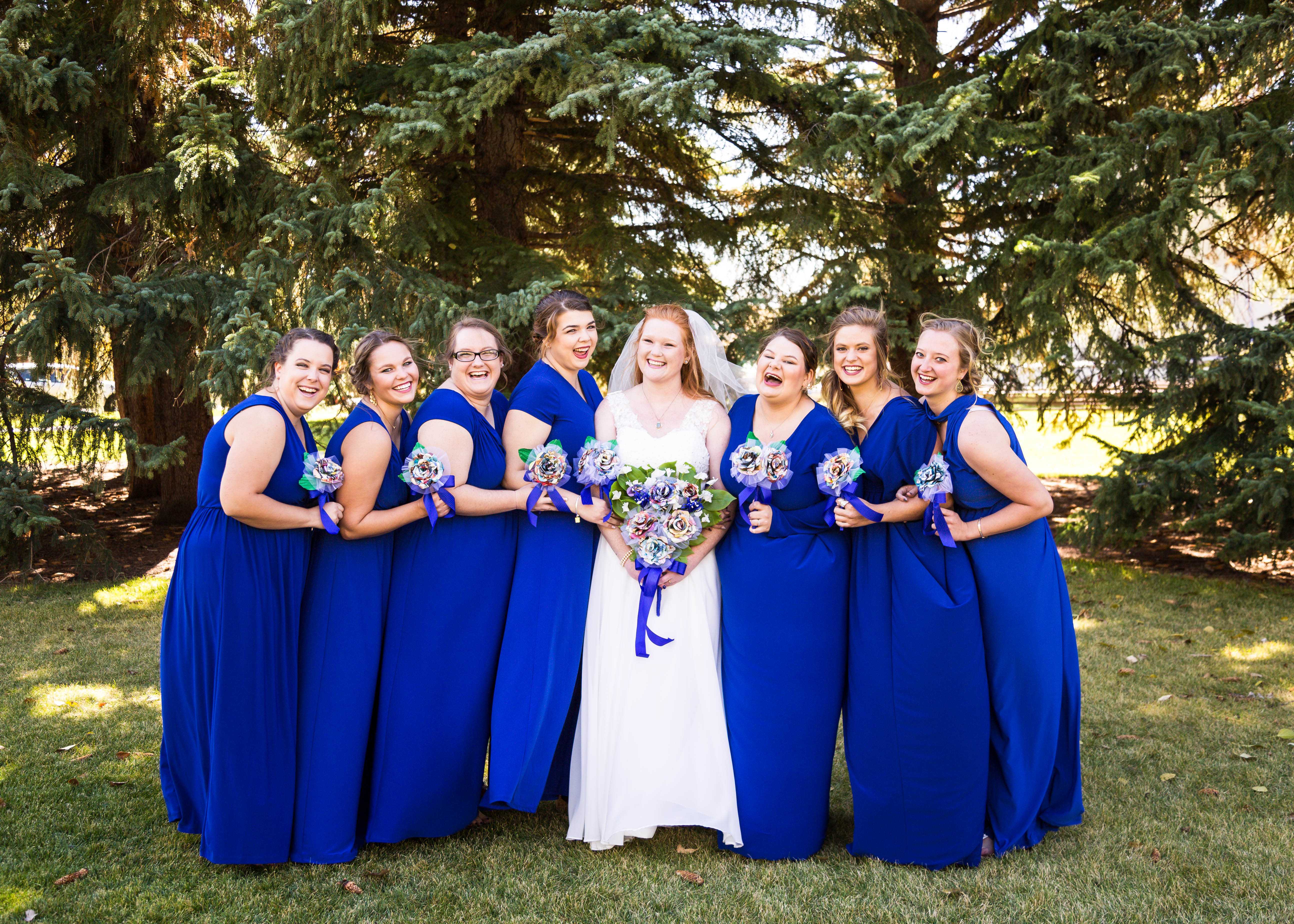 bride and bridesmaids laugh as they pose together