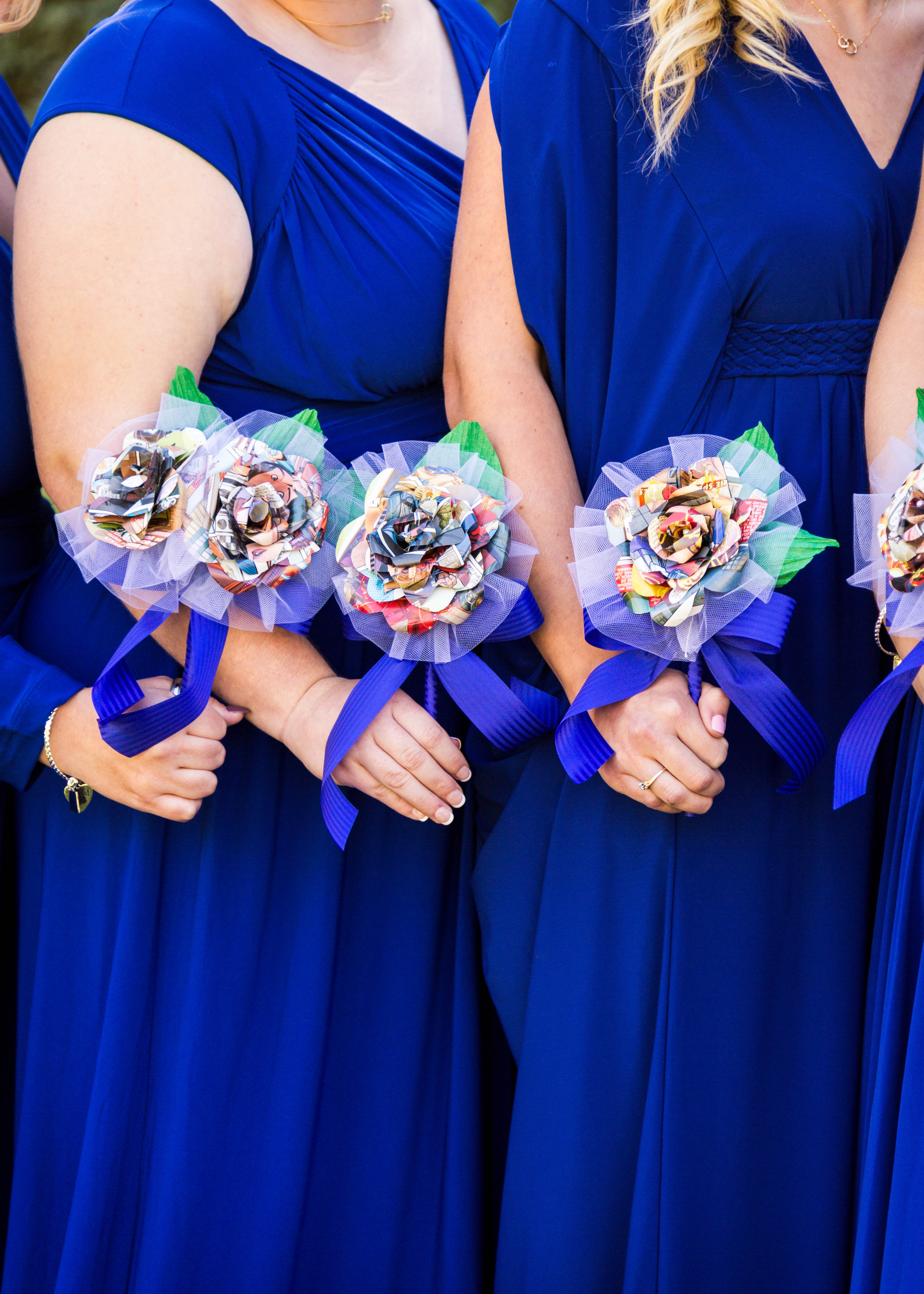 closeup of bridesmaids in royal blue dresses holding colorful paper flower bouquets