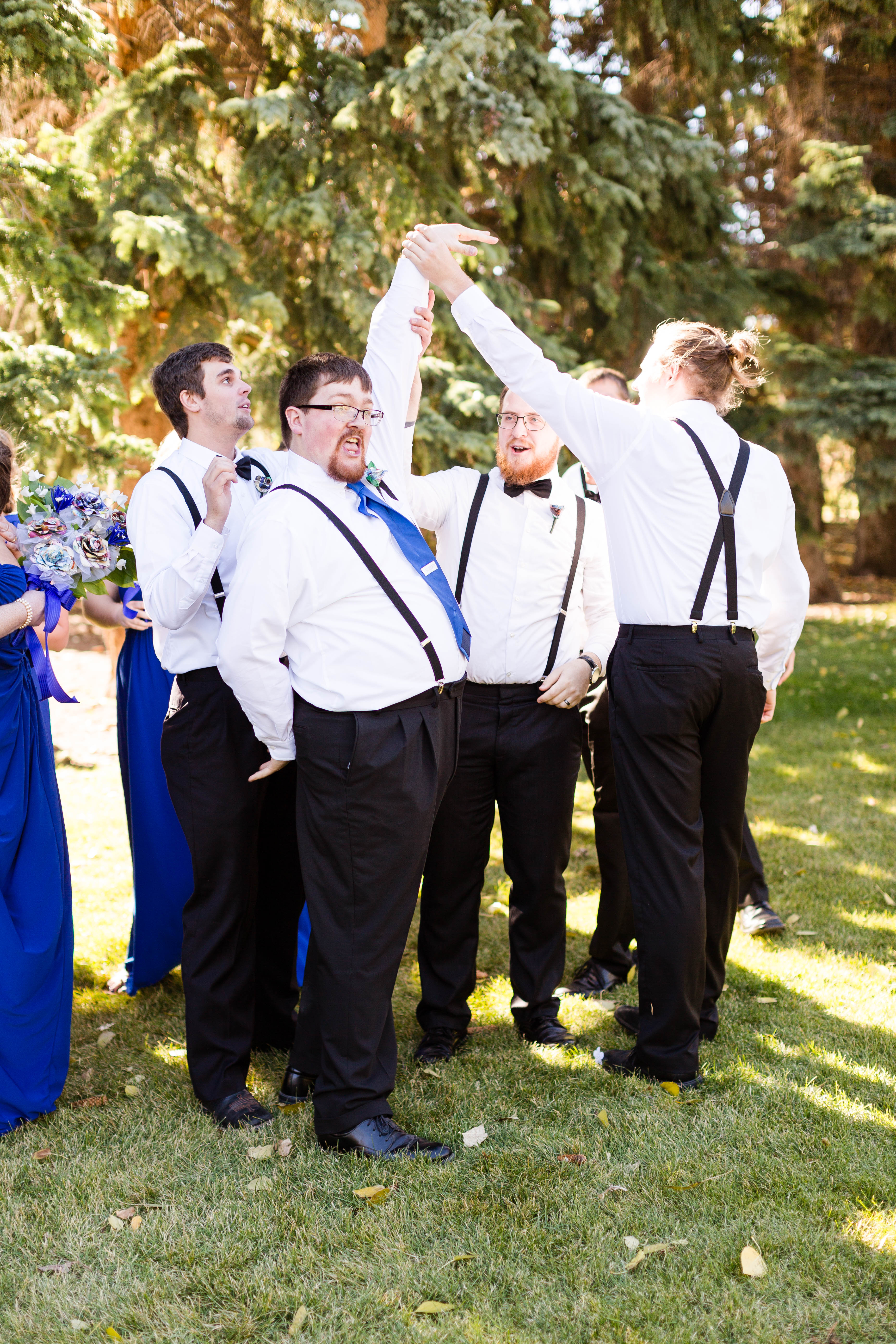 groom celebrates and shows off his ring to his groomsmen after wedding ceremony