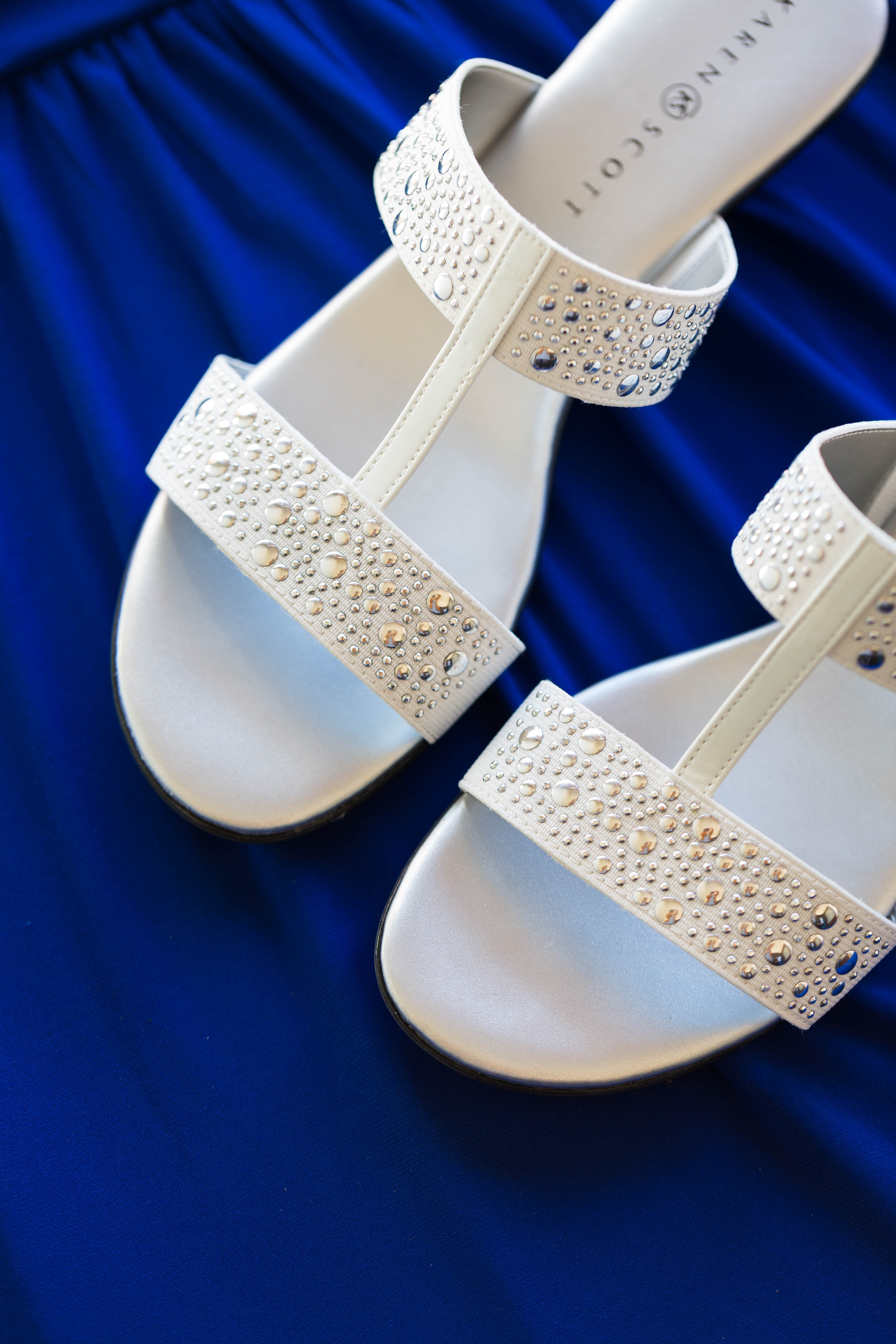 closeup of of bride's silver studded strapped sandals