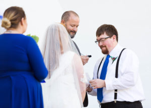 groom smiles and speaks into microphone during vows