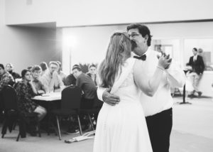father kisses the bride's forehead during the father-daughter dance