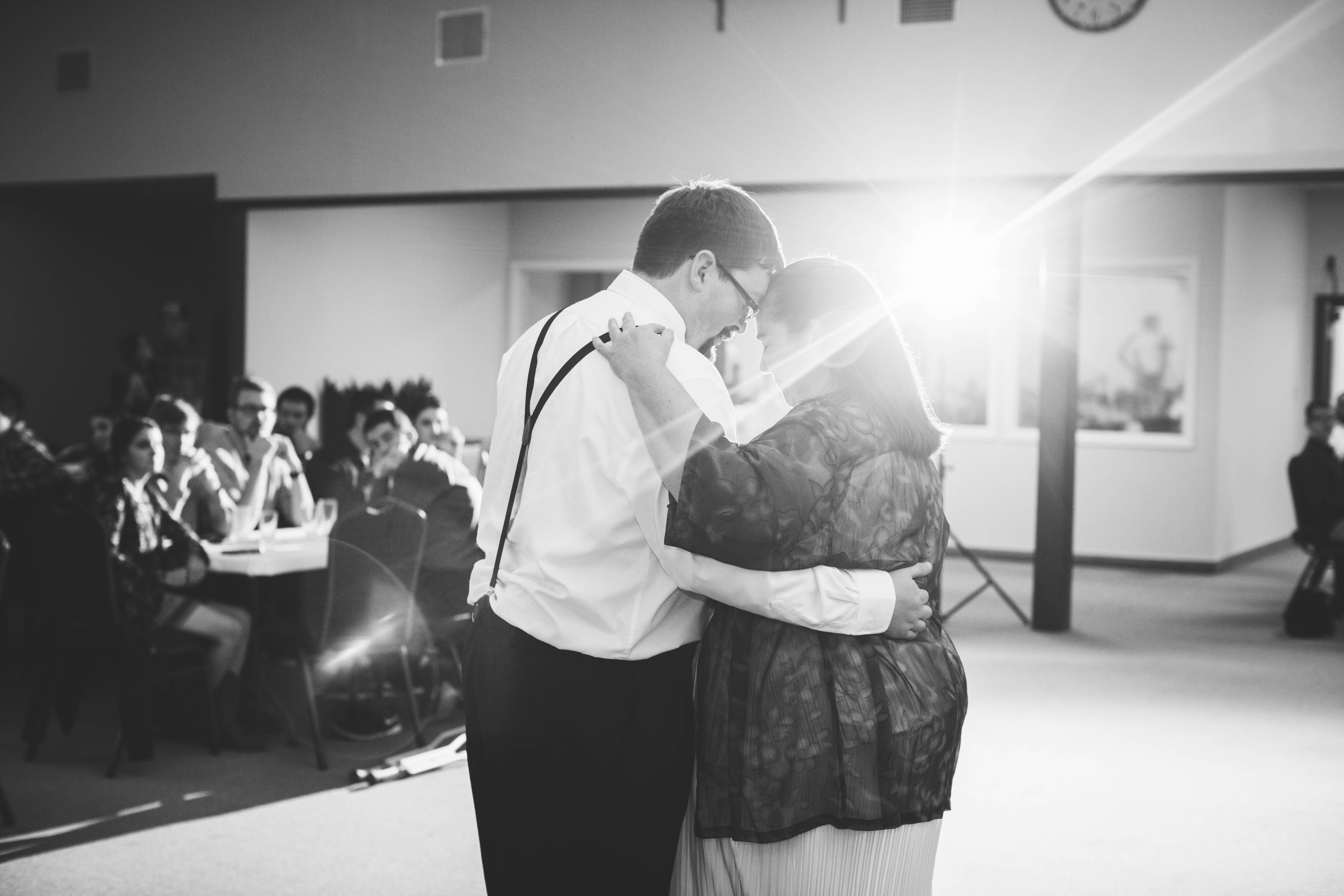 groom and his mother touch foreheads during the mother-son dance