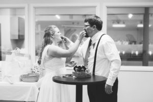 bride and groom feed each other a piece of wedding cake