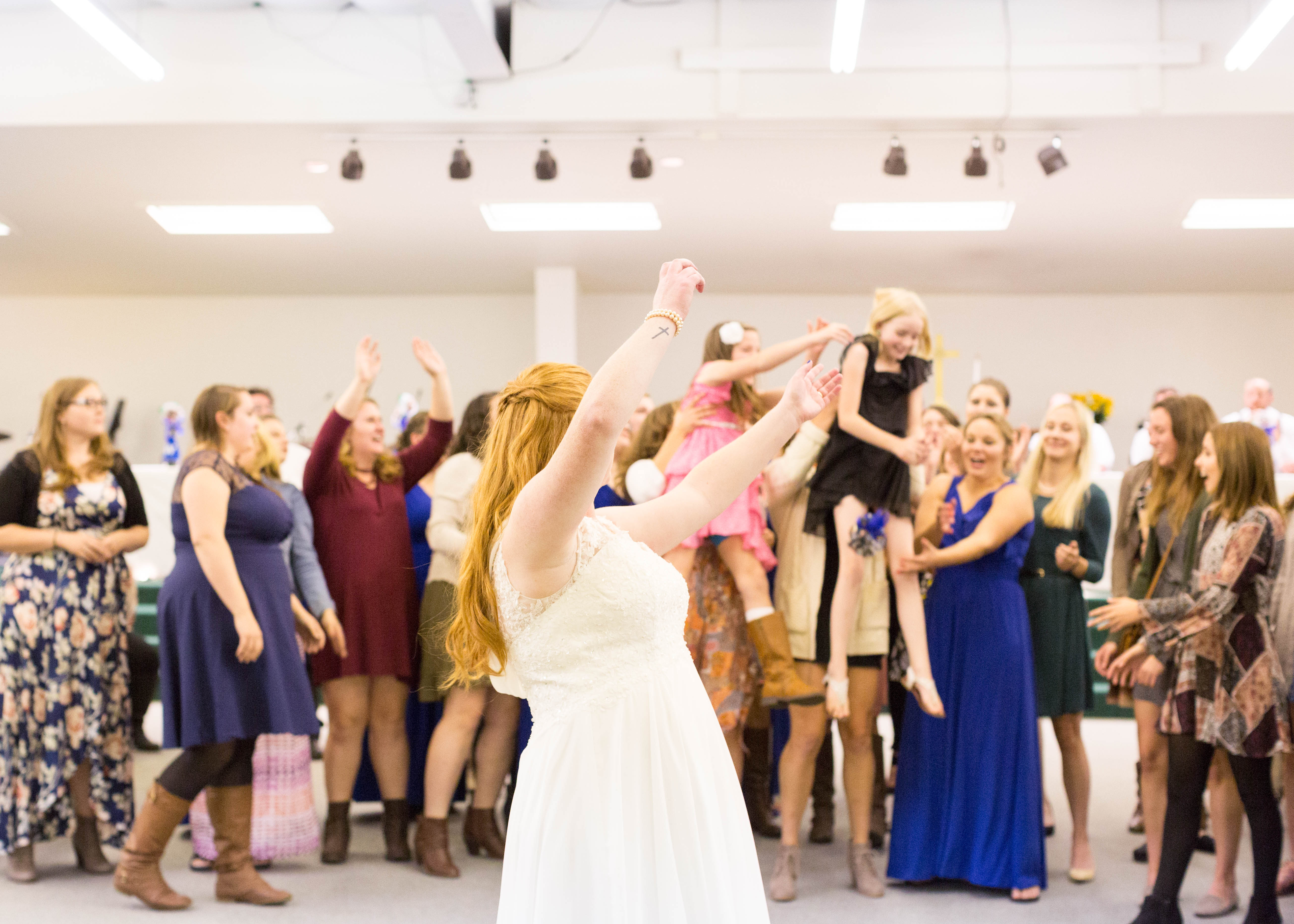 Bride turns to watch the single women catch her bouquet