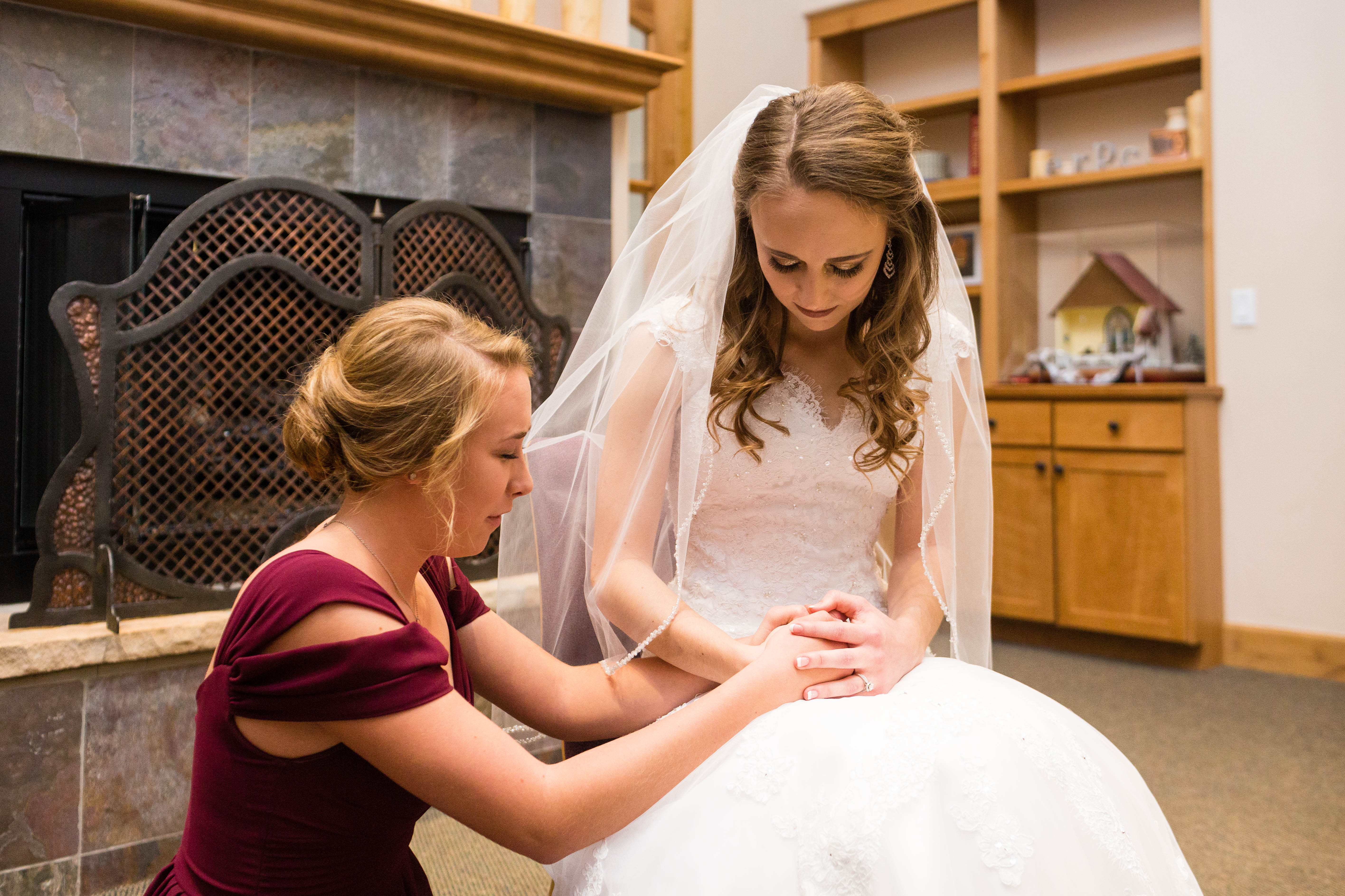Bride prays with her sister before the ceremony