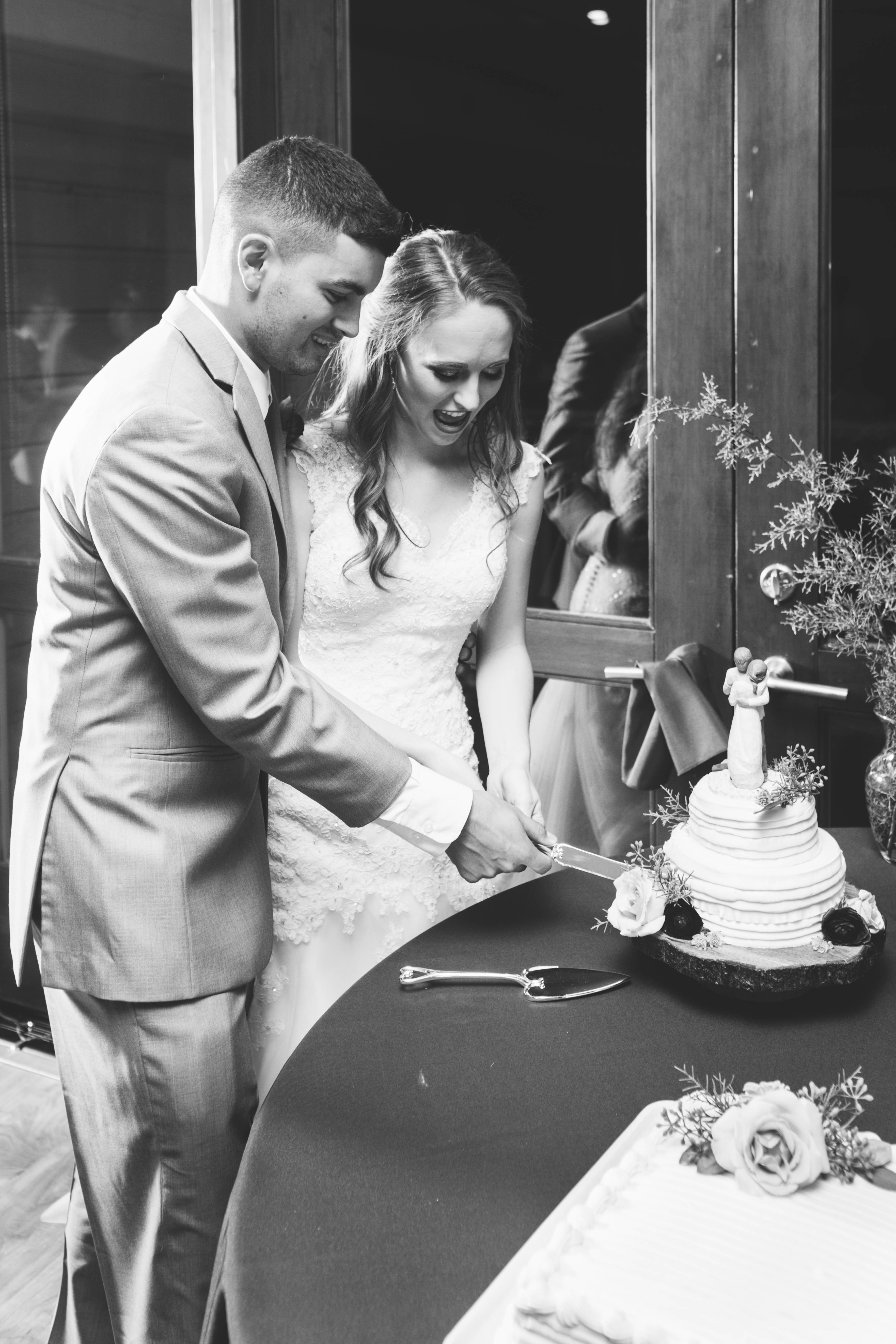 bride and groom smile as they cut their cake