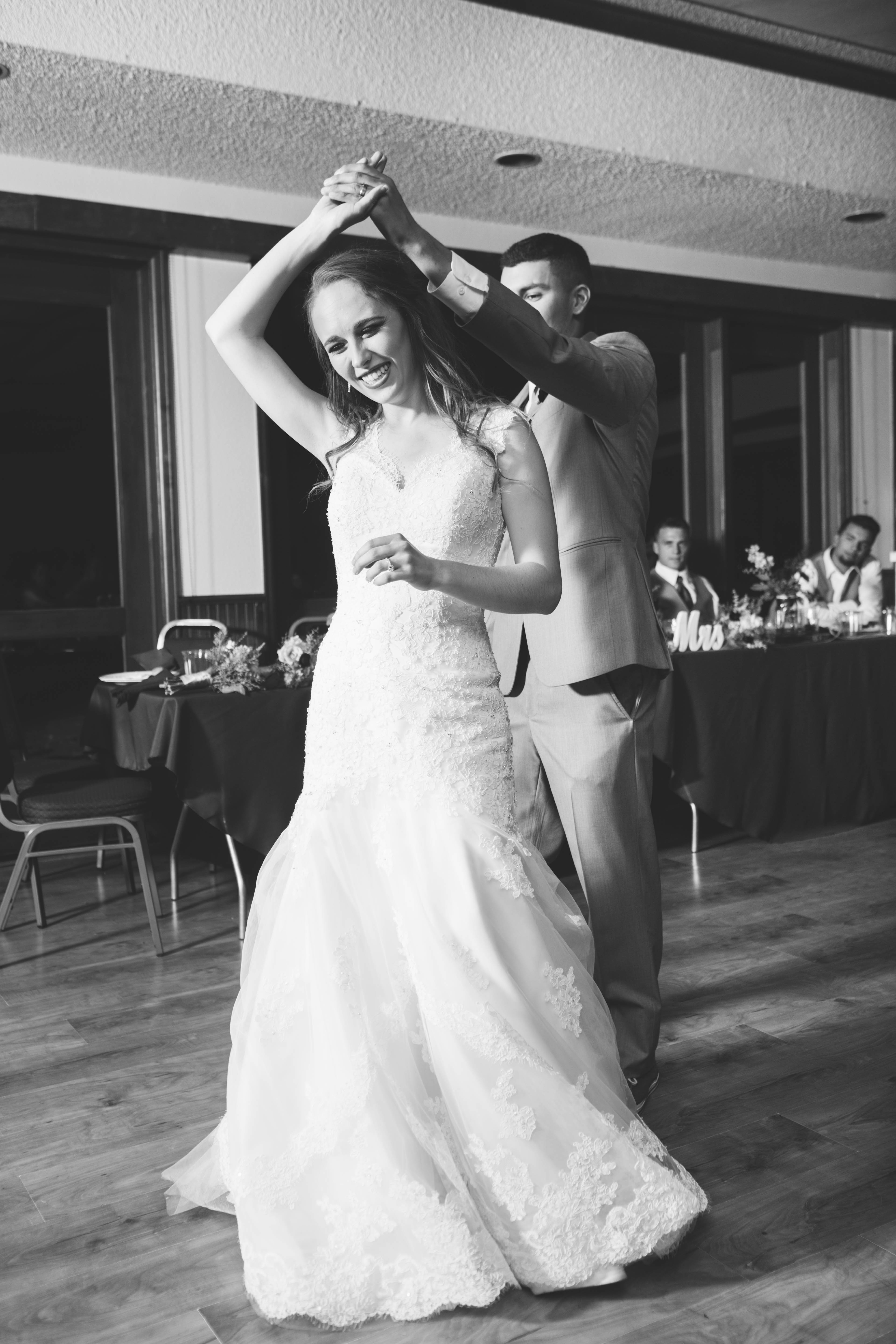 Bride laughs as groom twirls her