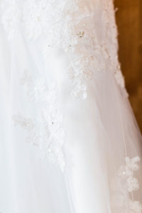 closeup of crystal beading on a white lace wedding dress