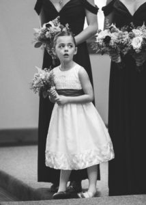 flower girl looks over at bride during the ceremony