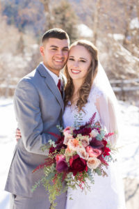 bride and groom press their cheeks together and smile on wintery wedding day