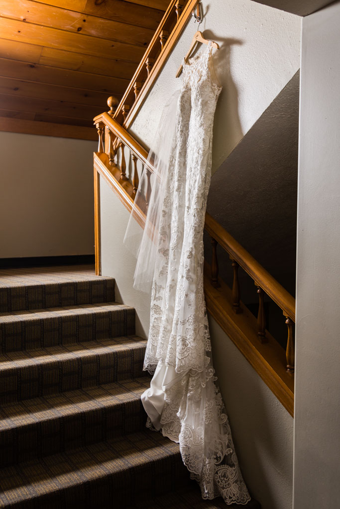 elegant lace wedding dress hanging in a stairwell