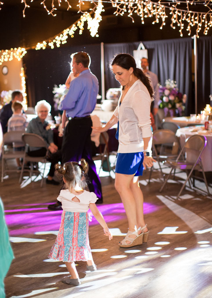 mom dances with young daughter at reception