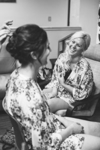 Bride laughs with her sister while getting ready