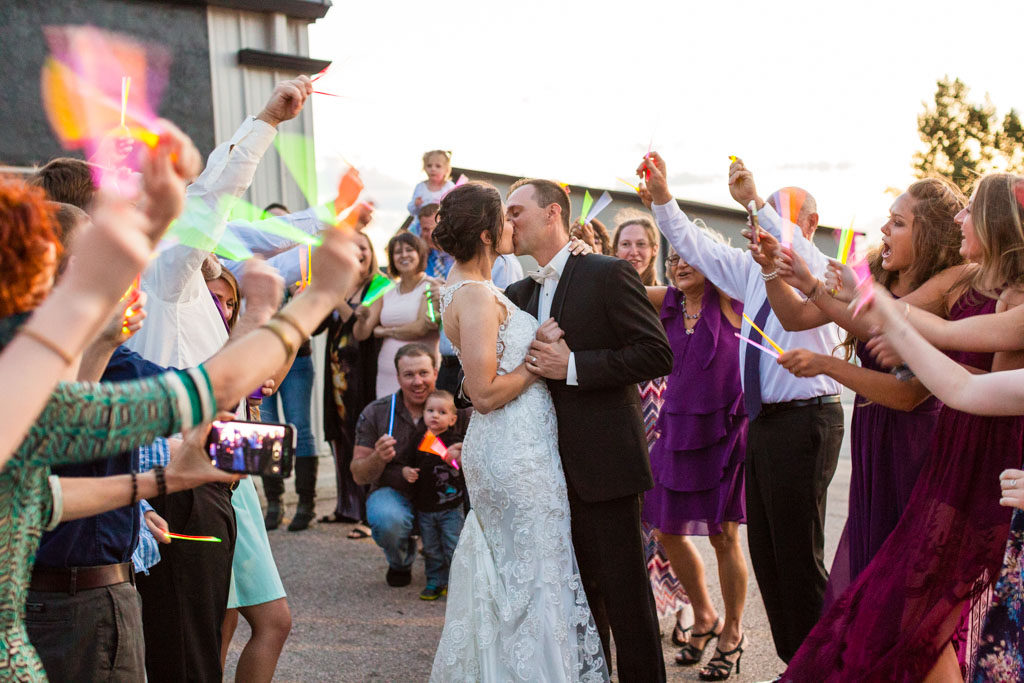 bride and groom kiss during glow stick exit