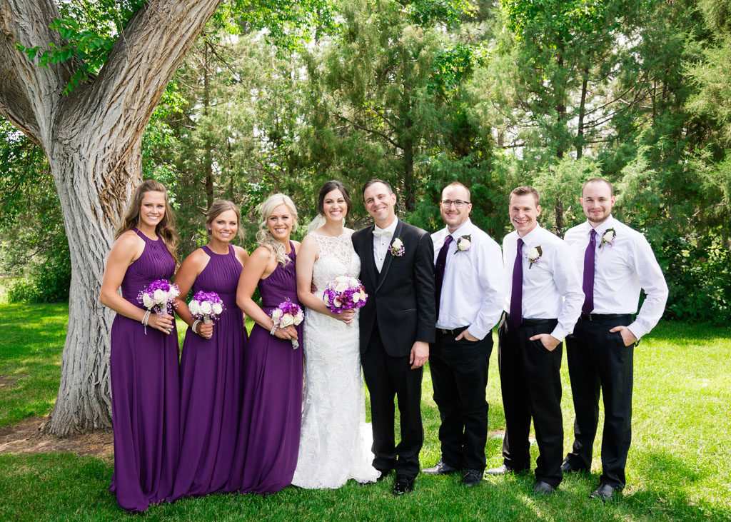 Bride and groom pose with wedding party for portrait