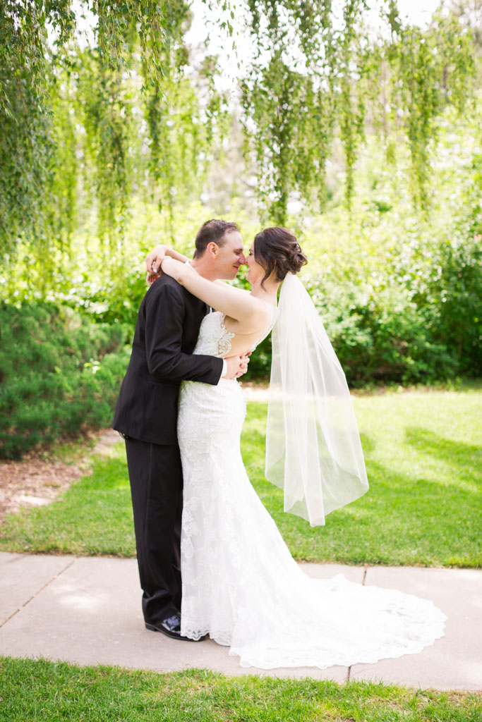Bride and groom kiss in a garden