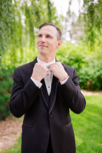 groom adjusts his bow tie