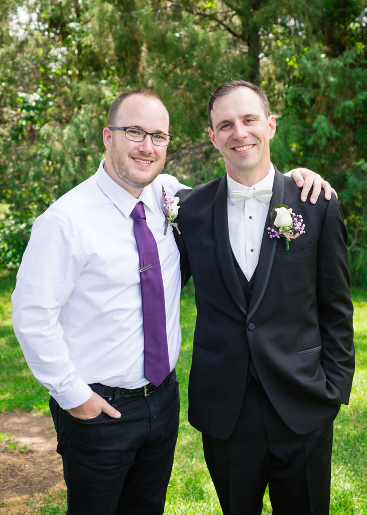 Groom poses with best man for portrait